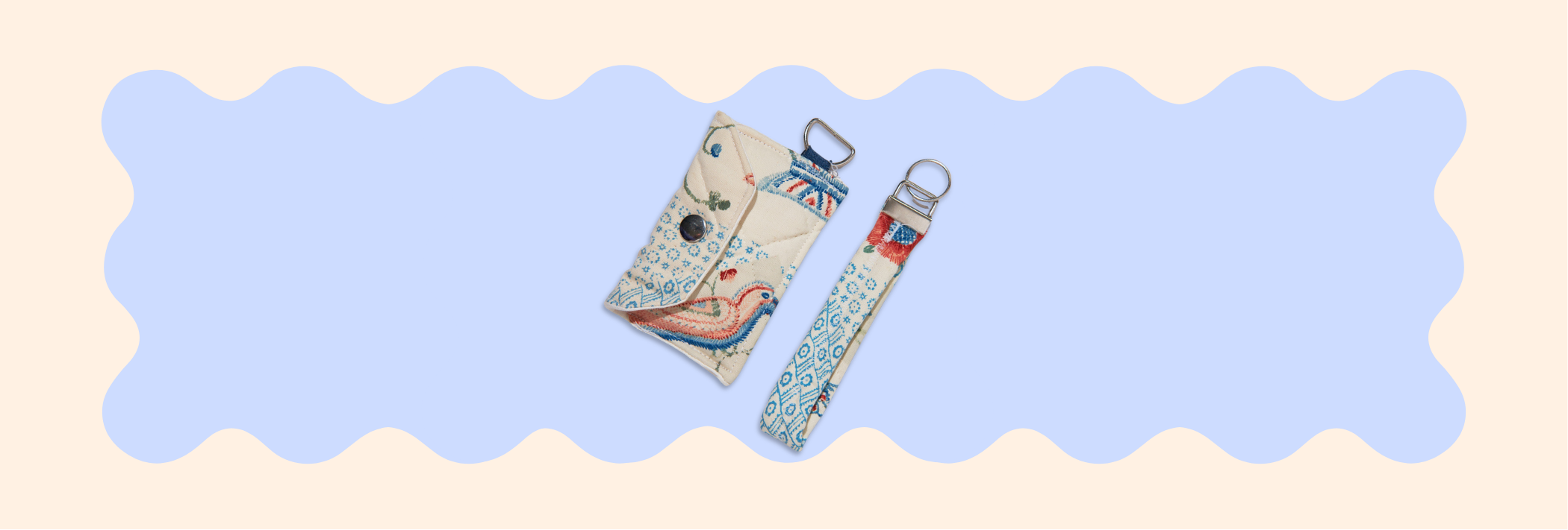 Two patterned key chains made of quilt fabric on a light blue and beige background