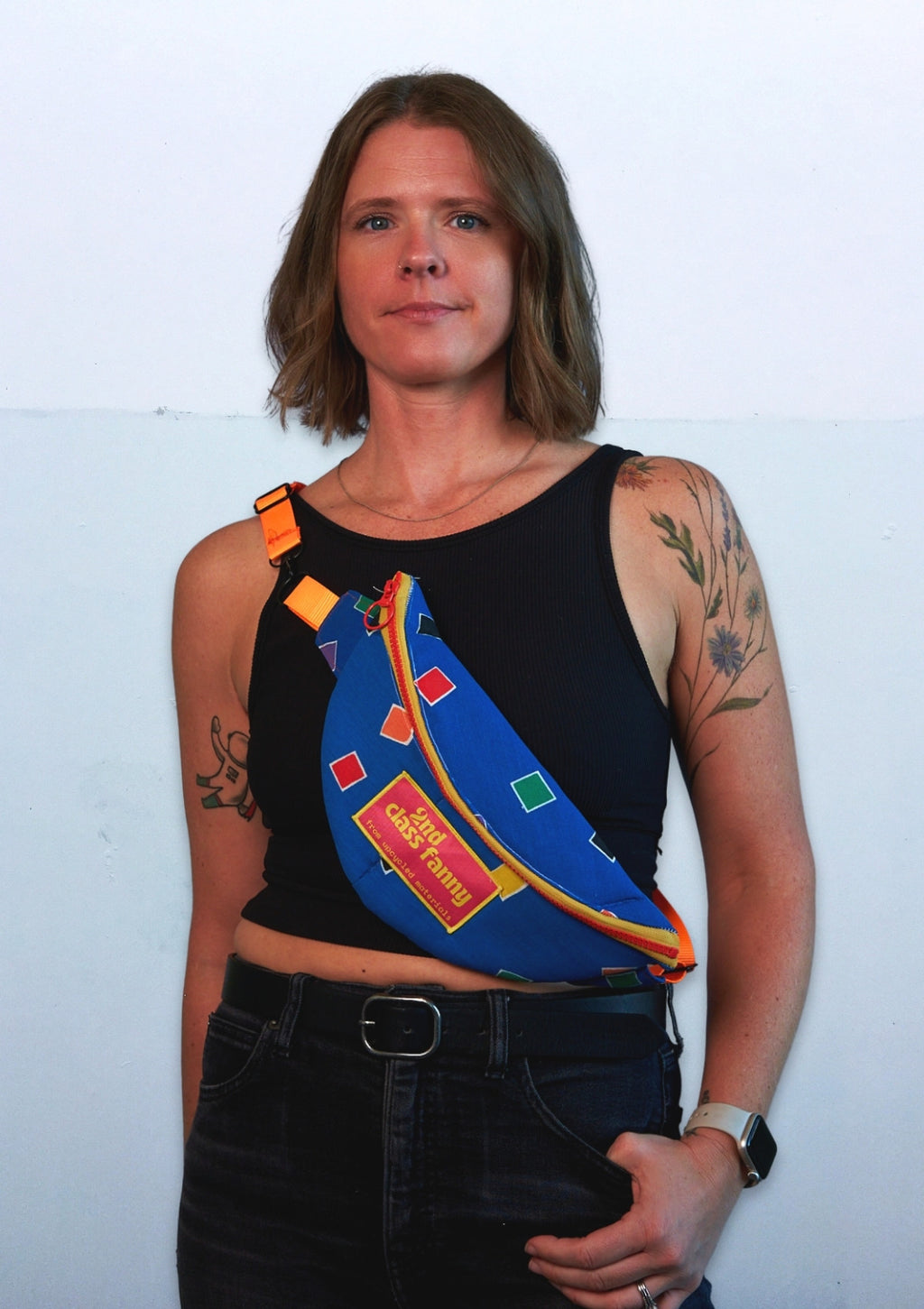 Person wearing a colorful satchel over one shoulder upcycled from comforter against a white background