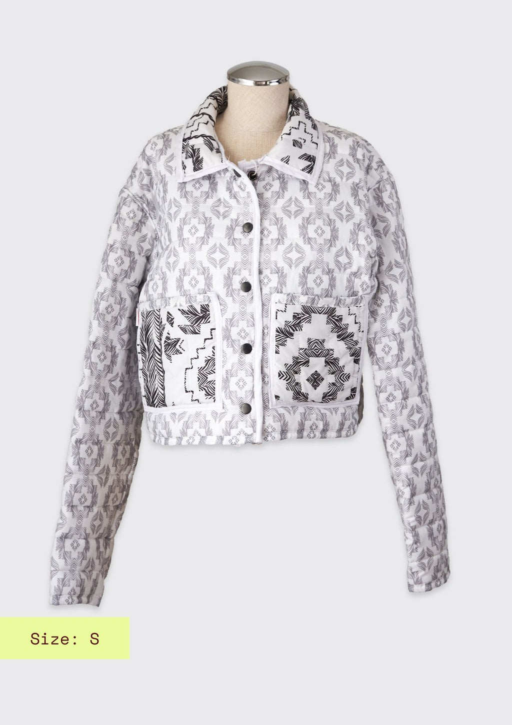 White and black jacket upcycled from a comforter on a mannequin against a white background