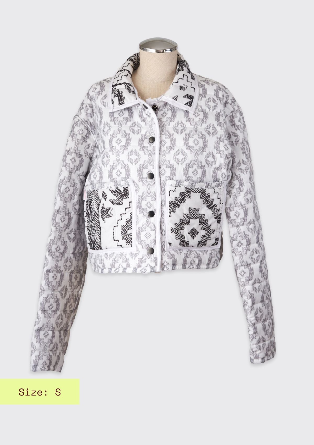 White and black jacket upcycled from a comforter on a mannequin against a white background