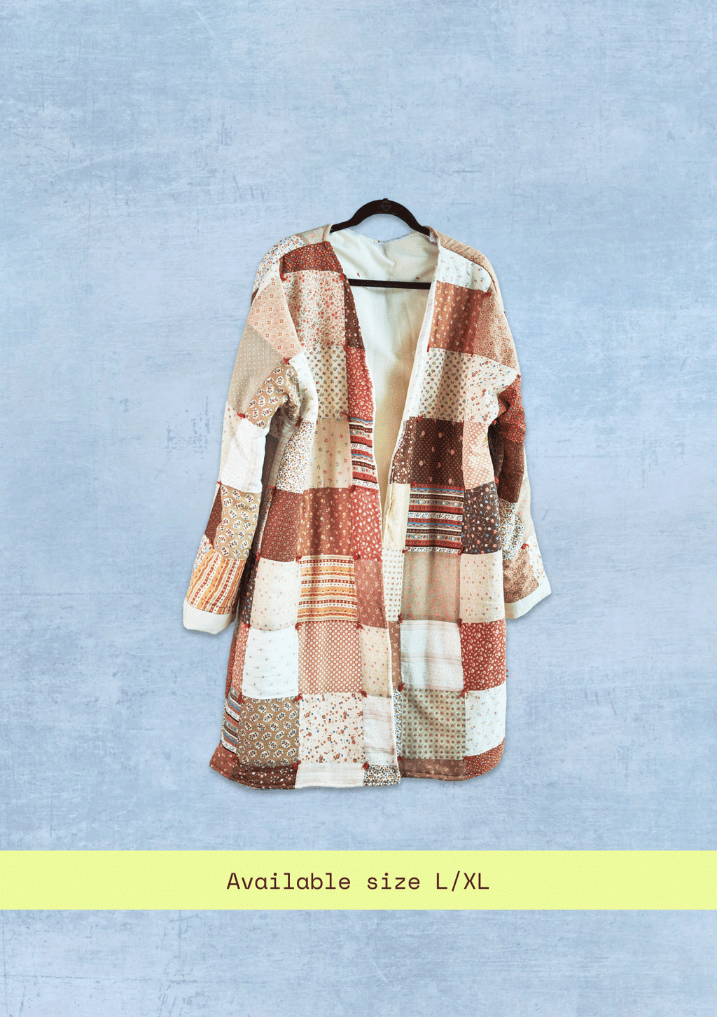 Patchwork coat on a hanger against a light blue background