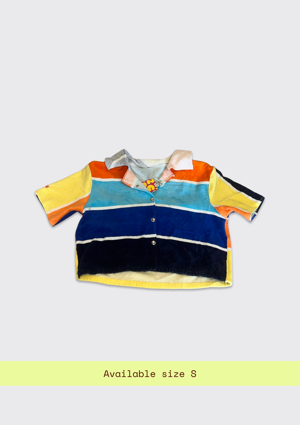 Colorful striped shirt upcycled from a beach towel on a light gray background