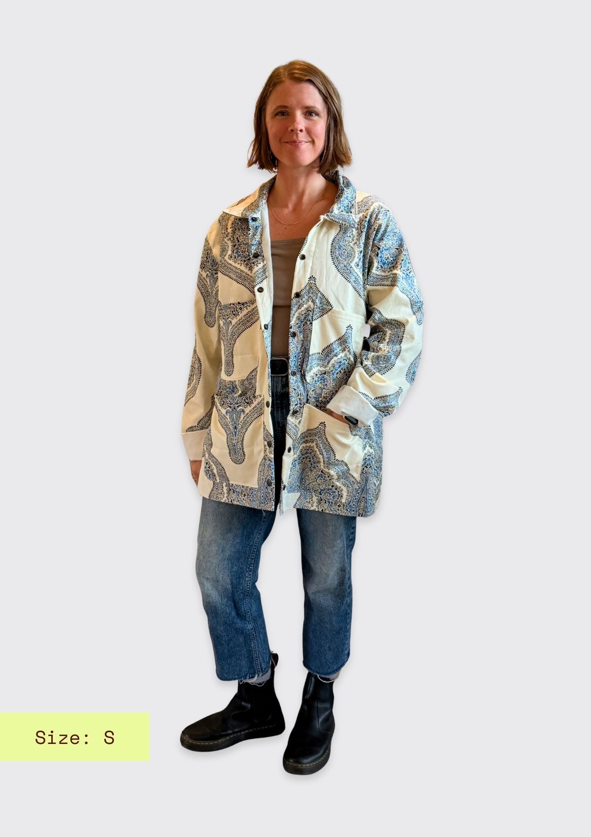 Woman wearing a patterned upcycled from a curtain jacket on a white background
