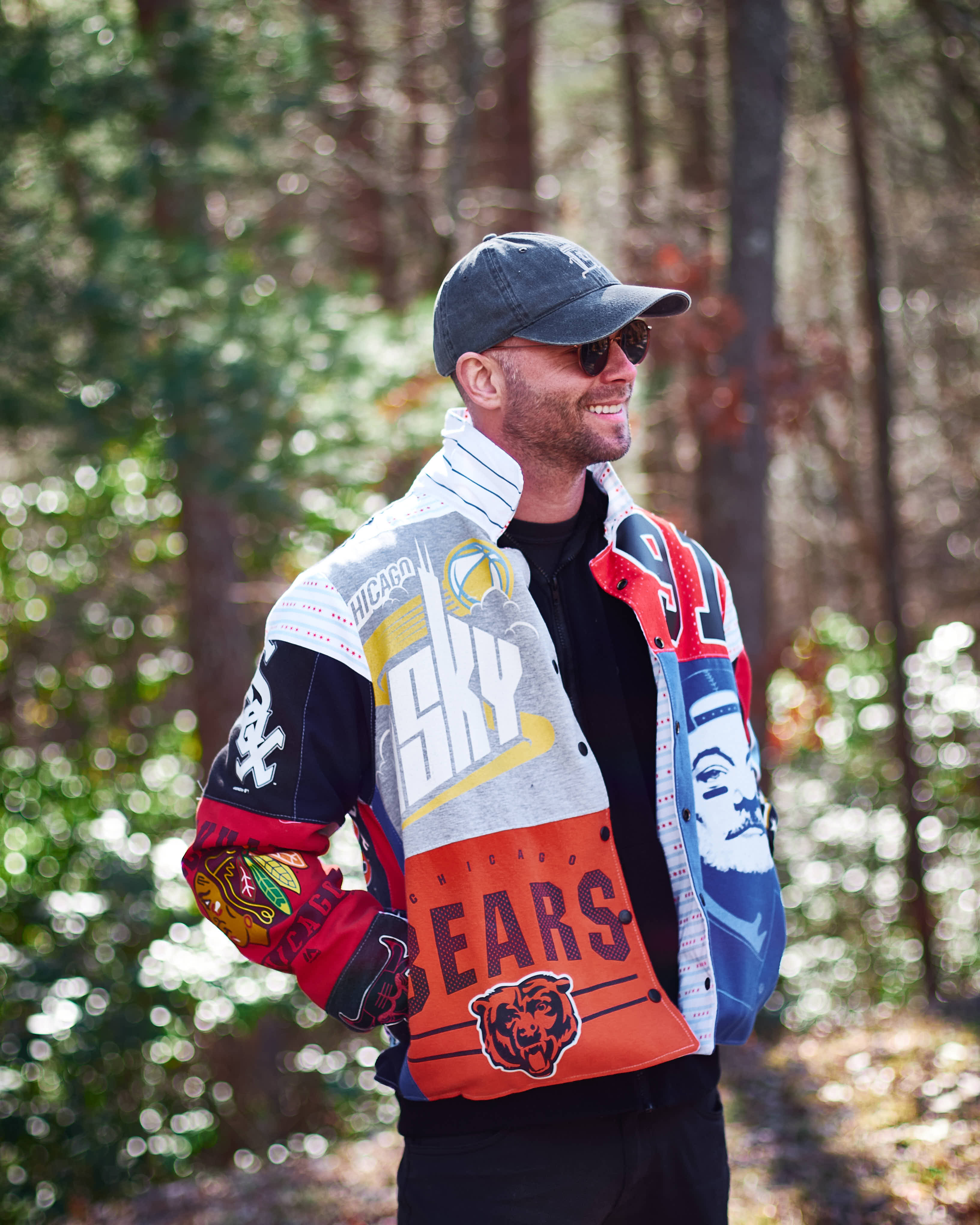 Man wearing a colorful sports jacket upcycled from sports shirts with logos in a forest setting