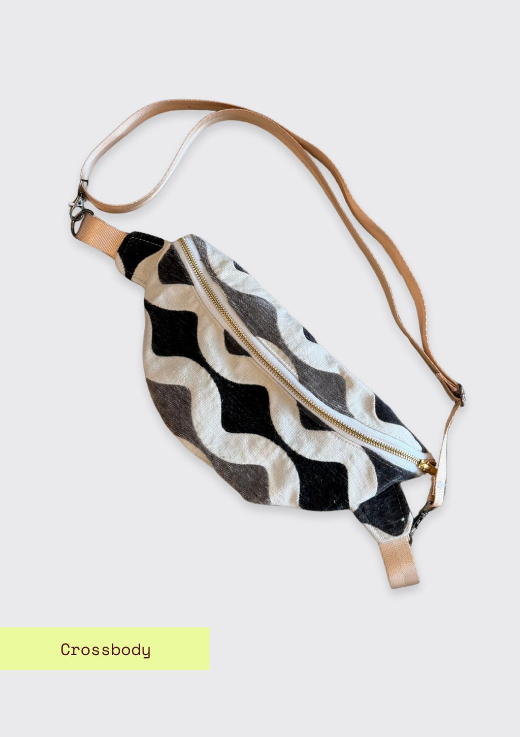 Crossbody bag with black and white zigzag pattern upcycled from designer deadstock fabric on a light gray background