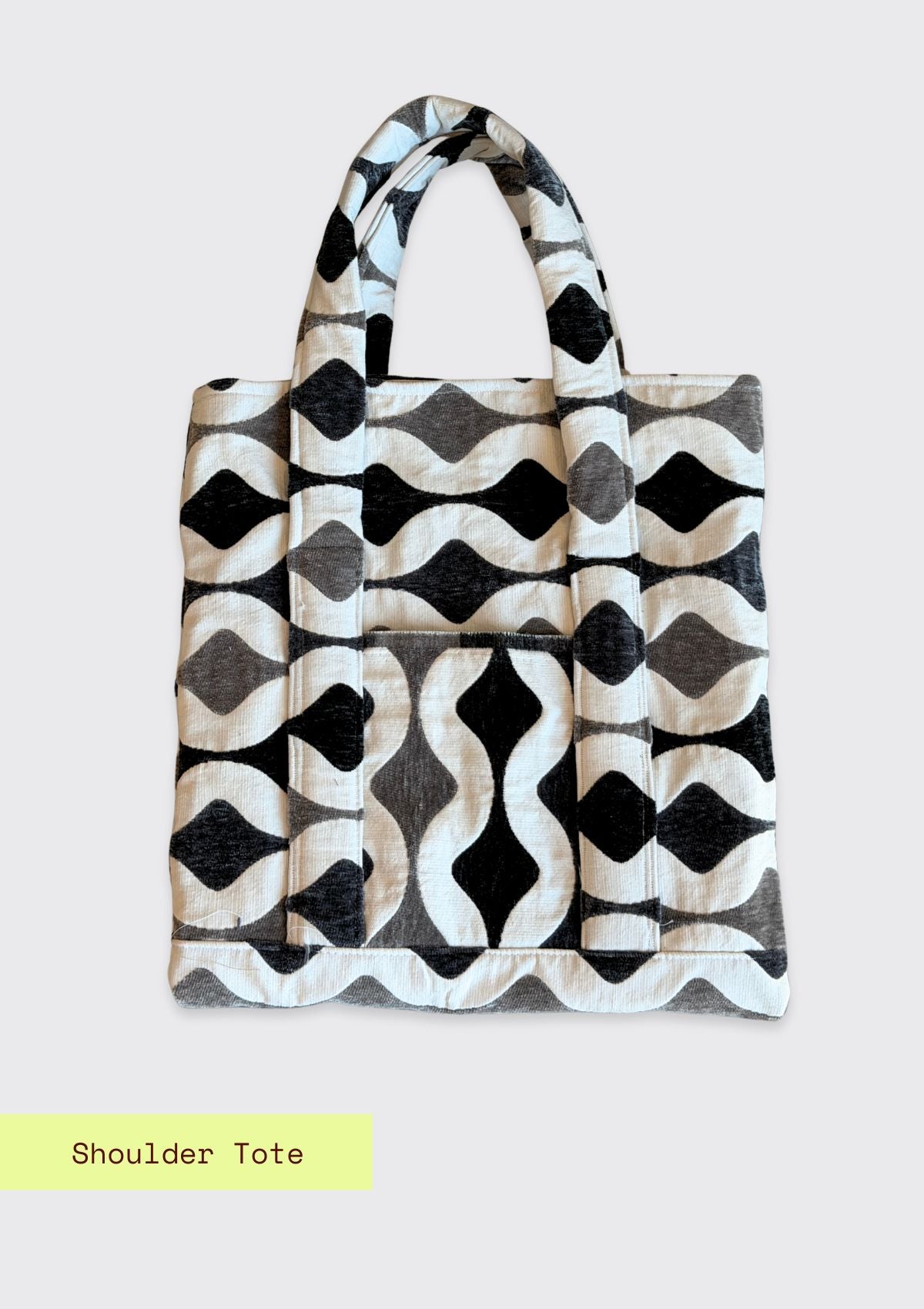 Black and white patterned shoulder tote bag upcycled from designer deadstock fabric on a light gray background