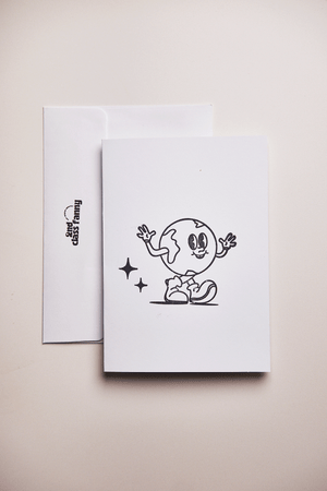 White card with envelope stamped with black illustration of a earth day character on a beige background