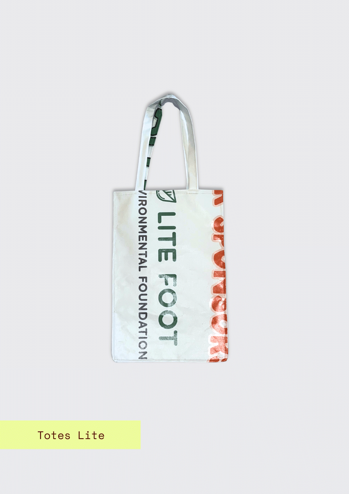 Tote bag with partial words, Lite Foot Foundation pattern, upcycled from an Earth Day Banner on a light blue textured background with Totes Lite branding.