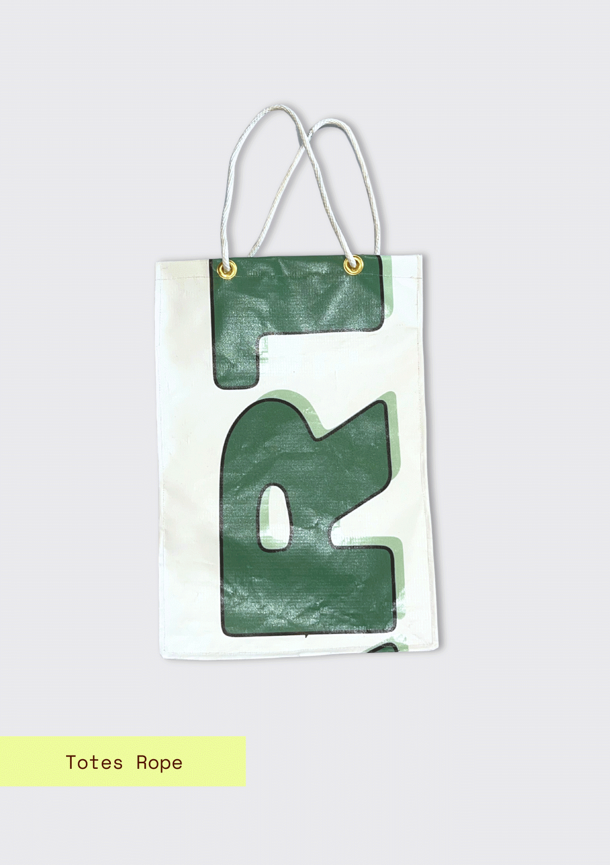 Tote bag with letters pattern with rope handle, upcycled from an Earth Day Banner on a light blue textured background with totes Rope branding.