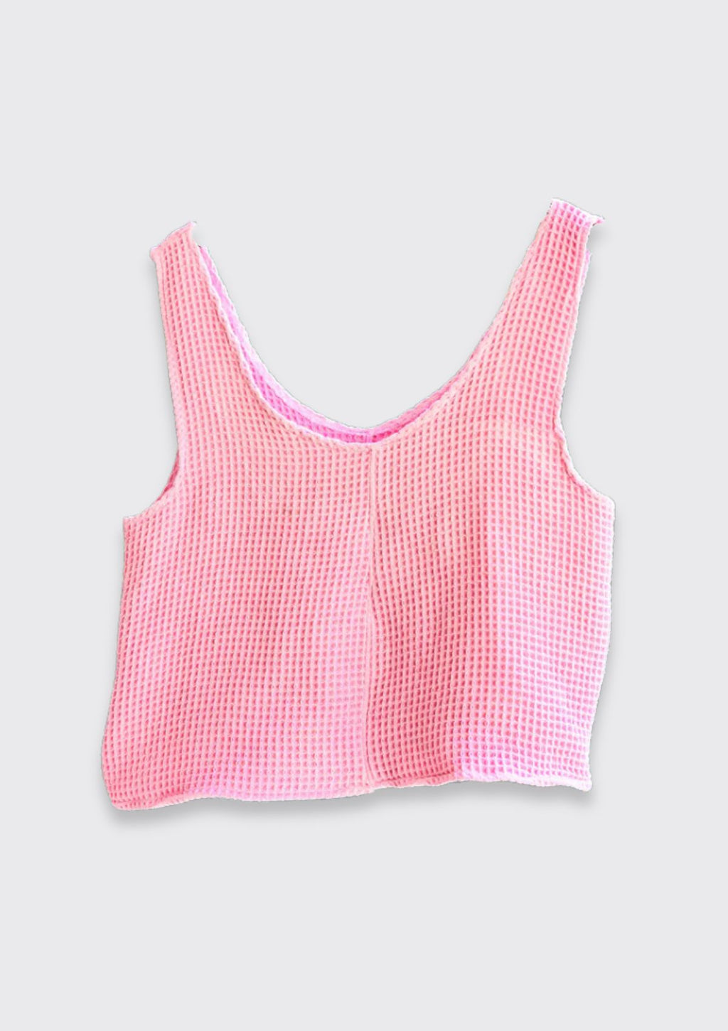 Pink checkered tank top from upycycled towel on a hanger against a white background