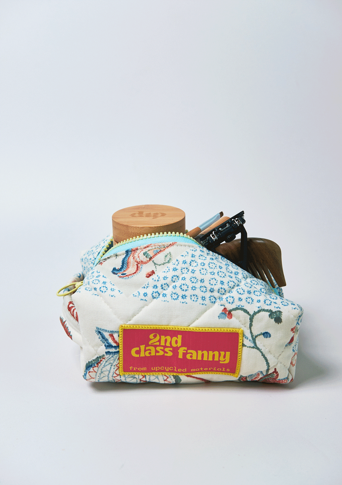 Small pouch with floral design and '2nd Class Fanny' label on a white background