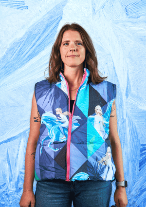 Person wearing a colorful vest with Frozen theme designs against a blue textured background