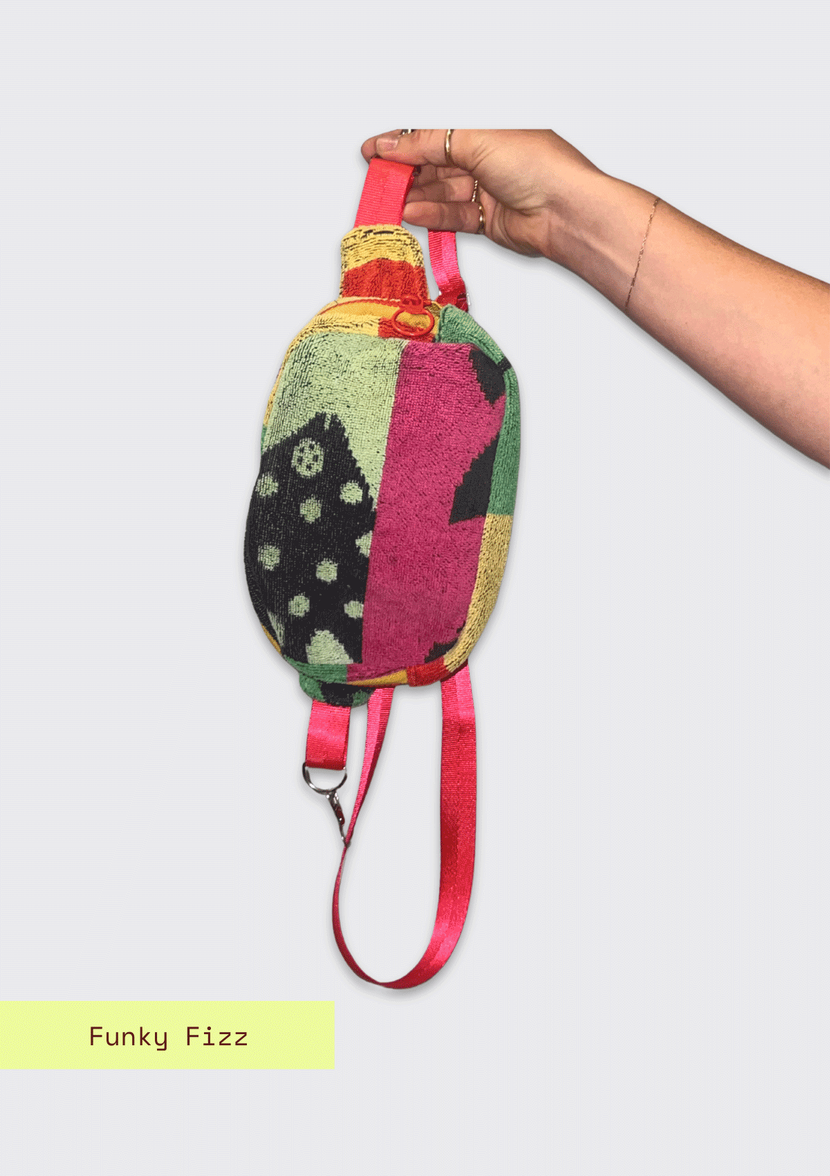 Colorful patterned fanny pack, upcycled from beach towel, held by a hand on a light gray background with 'Funky Fizz' branding.
