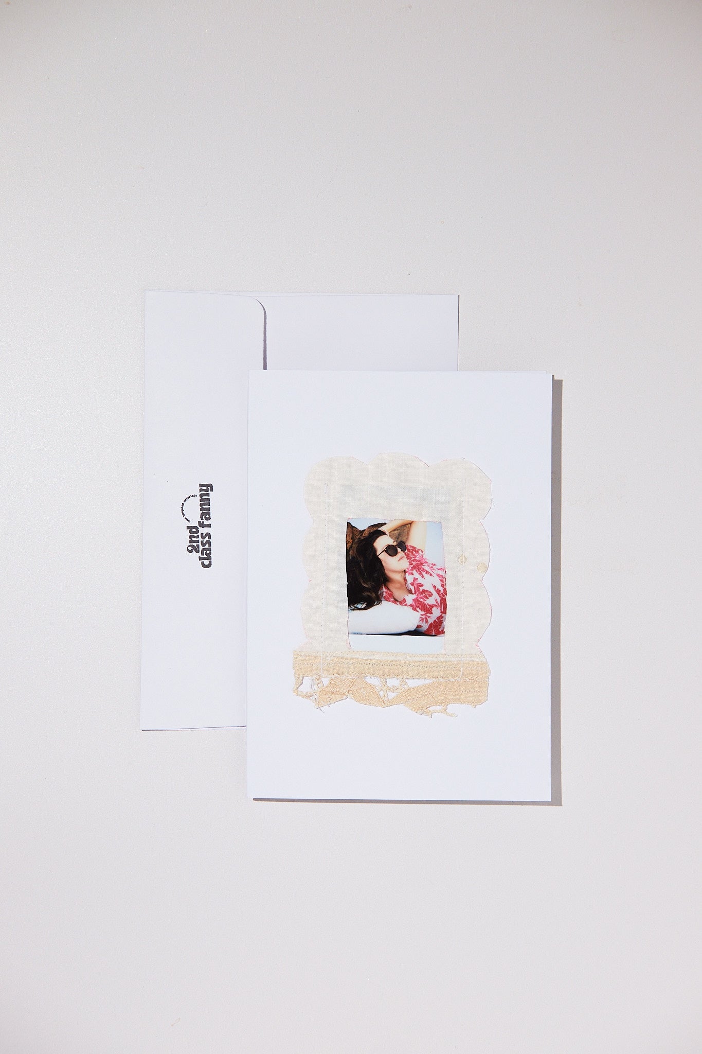 White card with envelope featuring an opening for your own Polaroid with a lace frame from upcycled lace curtains.