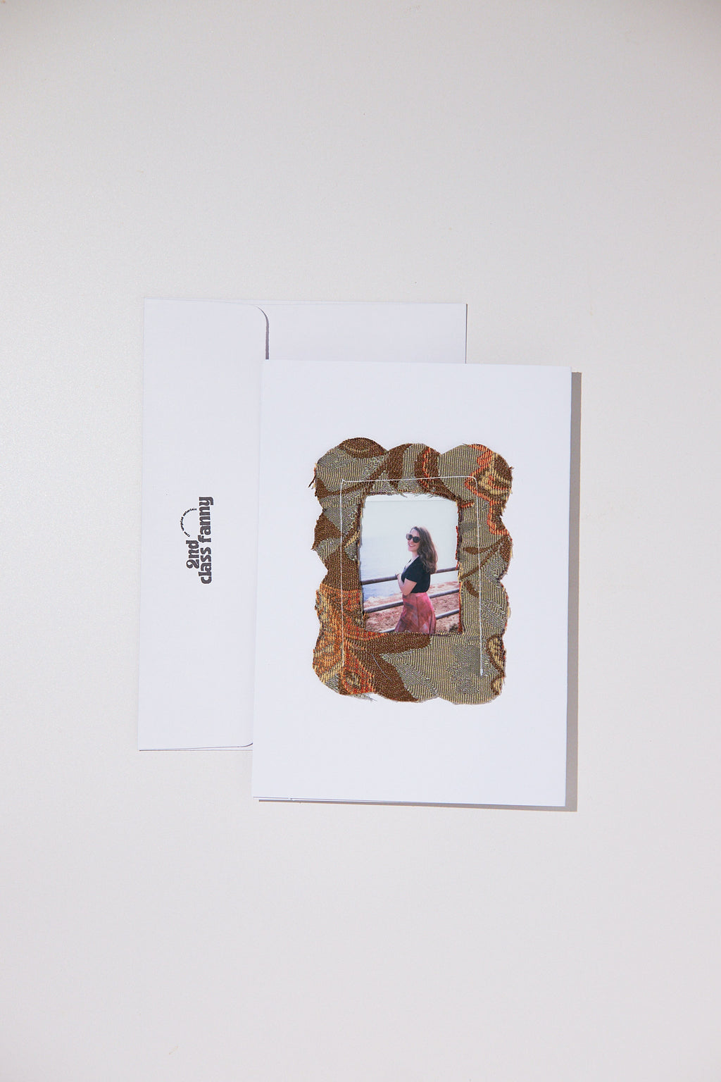 White card with envelope featuring an opening for your own Polaroid with a frame from upcycled curtains.