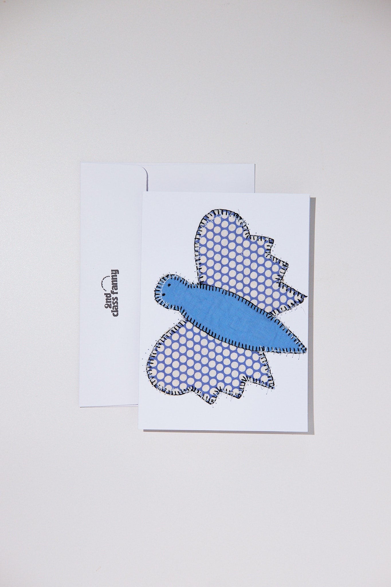 Blue butterfly design on a white card with a white envelope on a light gray background