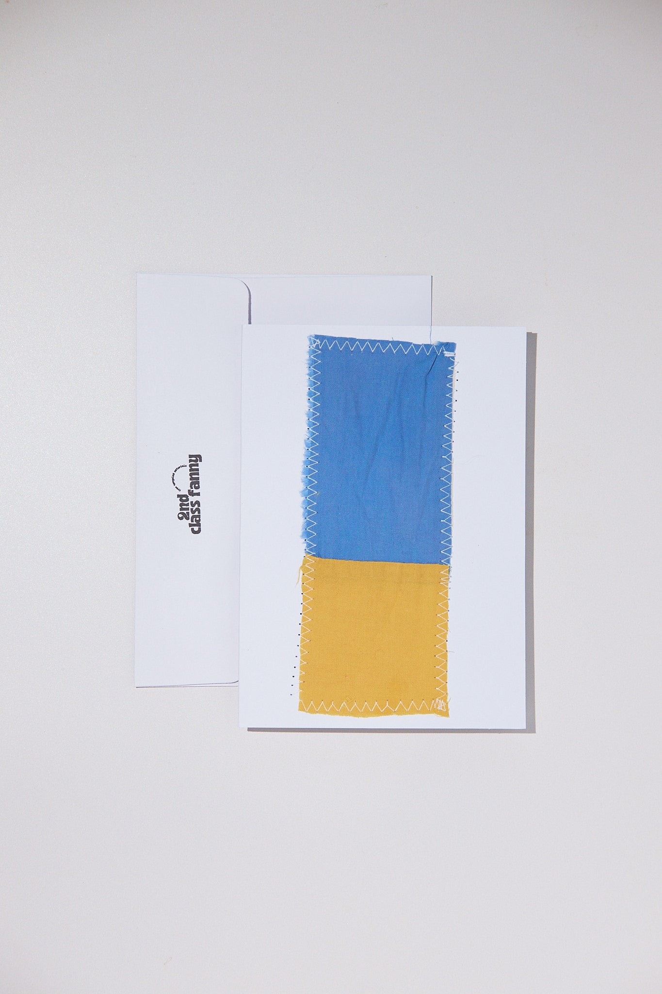 Color swatch with blue and yellow on a white card against a light gray background