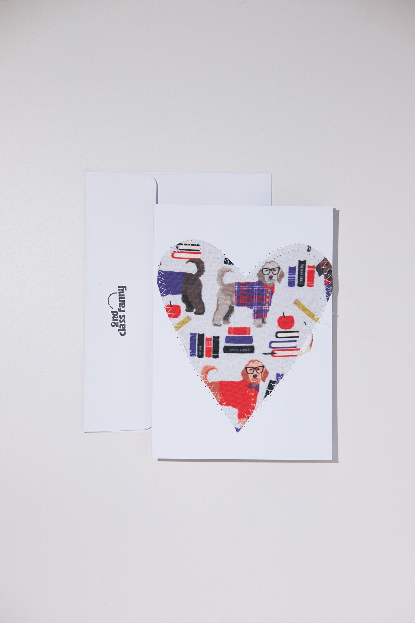 Card with a heart design featuring dogs and books on a white background