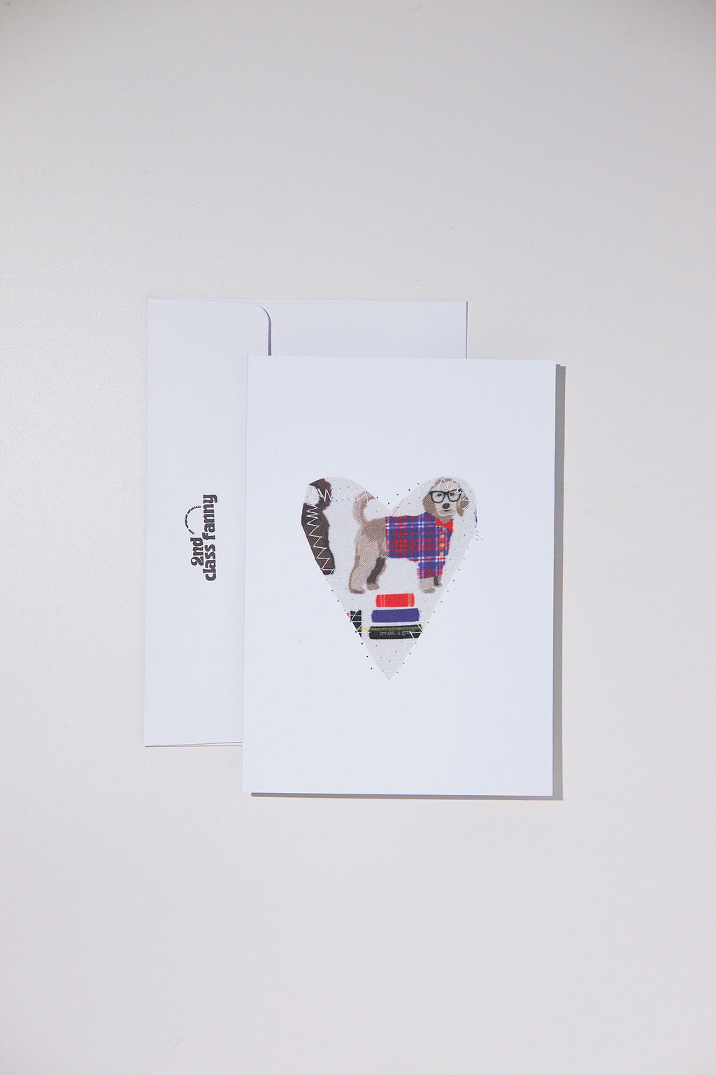 Greeting card with a dog wearing a plaid coat and scarf on a white background
