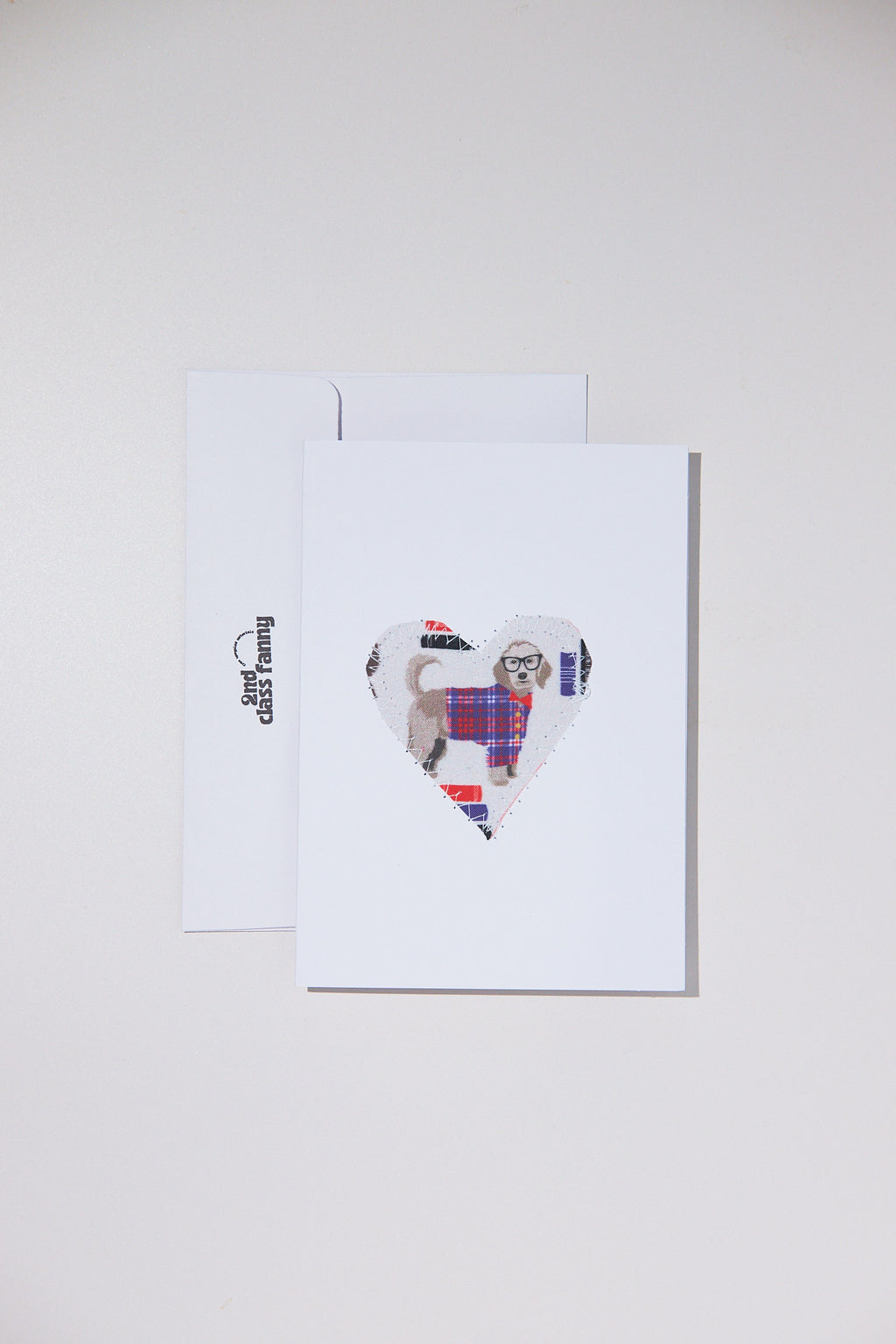 Framed artwork of a dog in a heart shape with tartan pattern on a white background