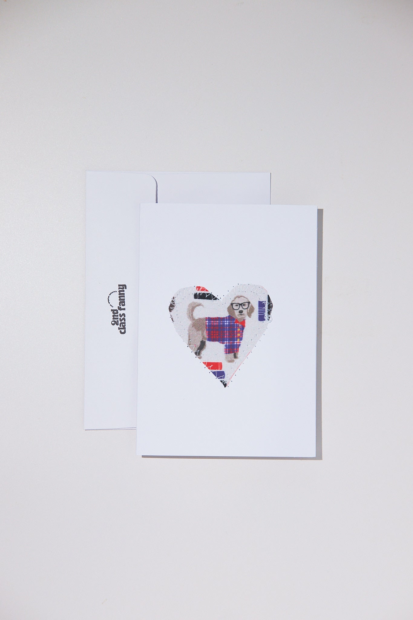 Framed artwork of a dog in a heart shape with tartan pattern on a white background