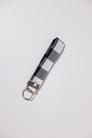 Keychain with a black and white checkered strap  upcycled from curtains on a light gray background