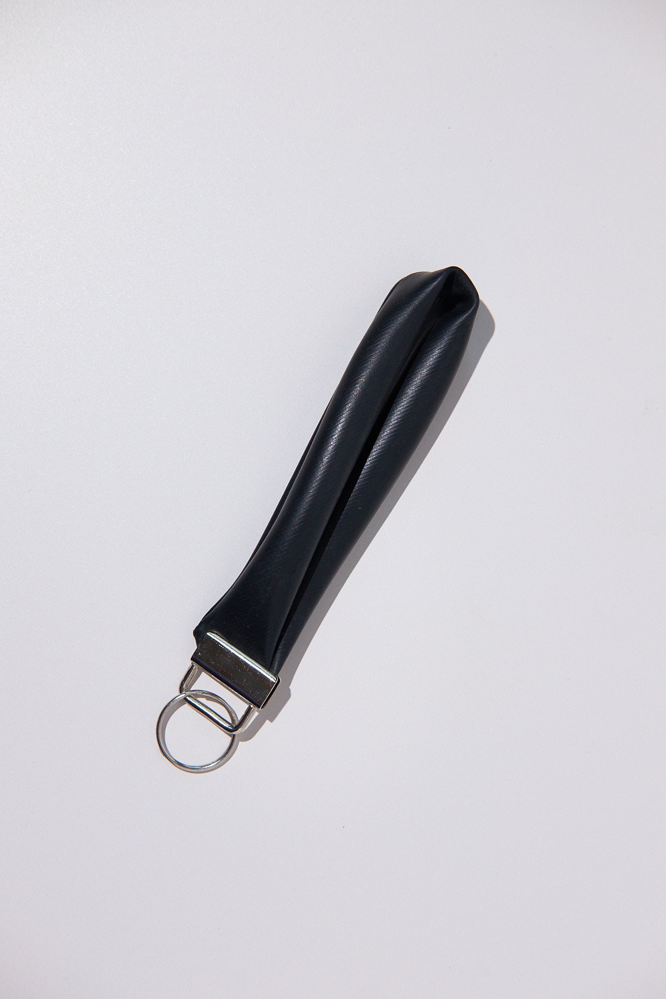 Black keychain upcycled from an inner tube on a white background