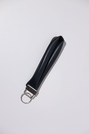 Black keychain upcycled from an inner tube on a white background