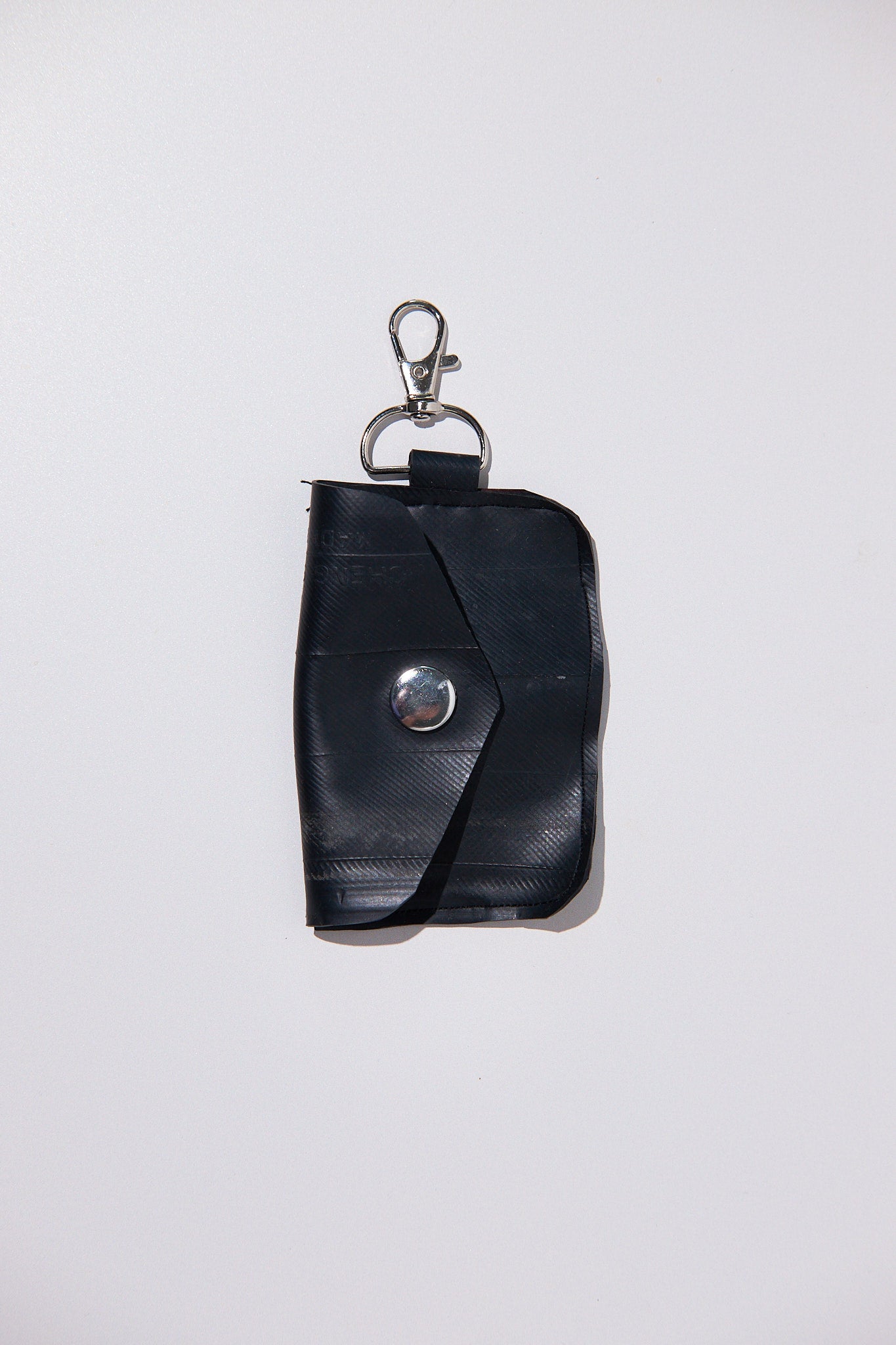 Black key case upcycled from inner tube on a white background