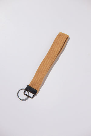 Brown keychain strap upcycled from a sweater with black clip on a white background