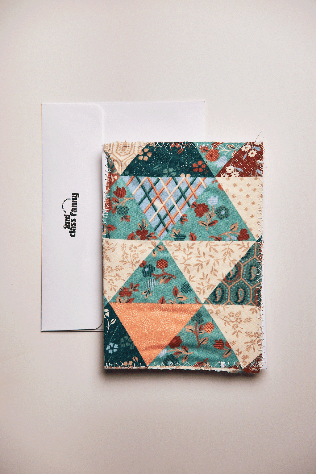 Colorful patchwork upcycled from a bed sheet on a white card on a beige background