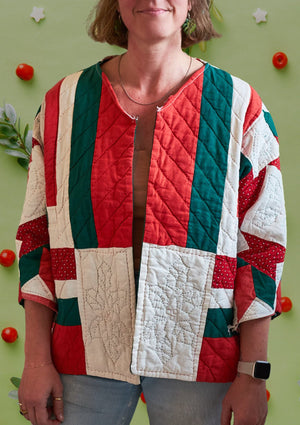 Person wearing a colorful red and green Christmas themed quilted jacket against a green background with decorative elements.