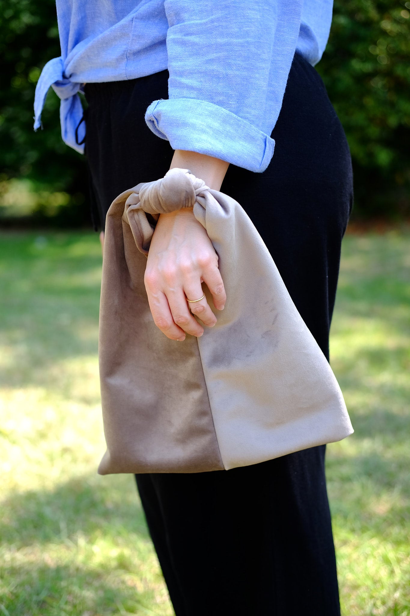 Person wearing a velvet knot bag on their wrist upcycled form designer deadstock fabric 