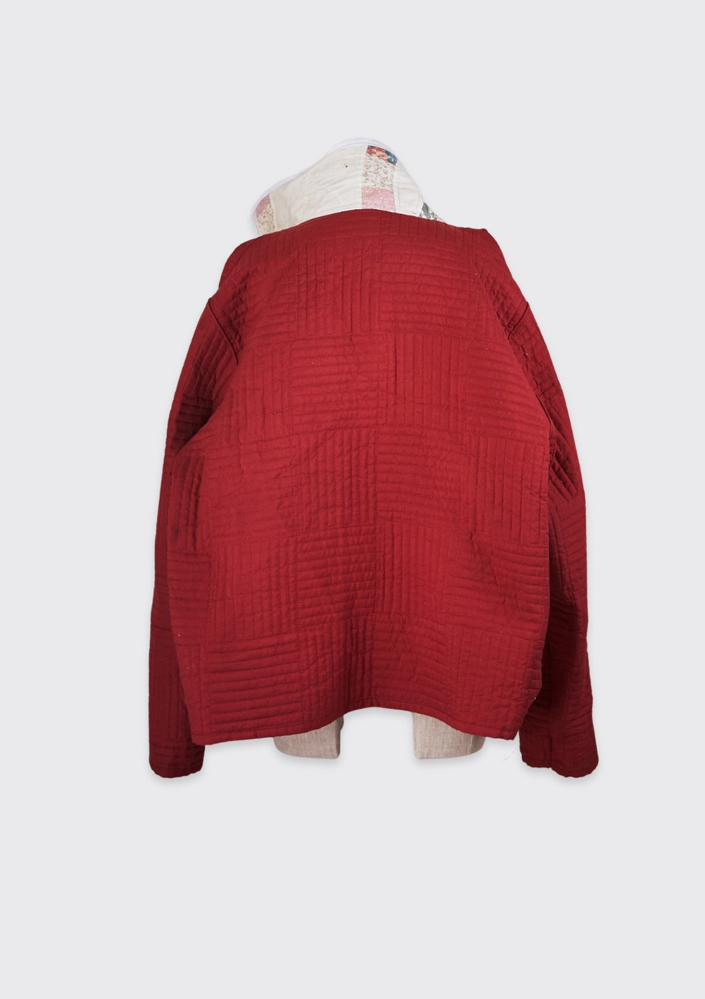 Red textured jacket with white collar upcycled from a quilt  on a white background