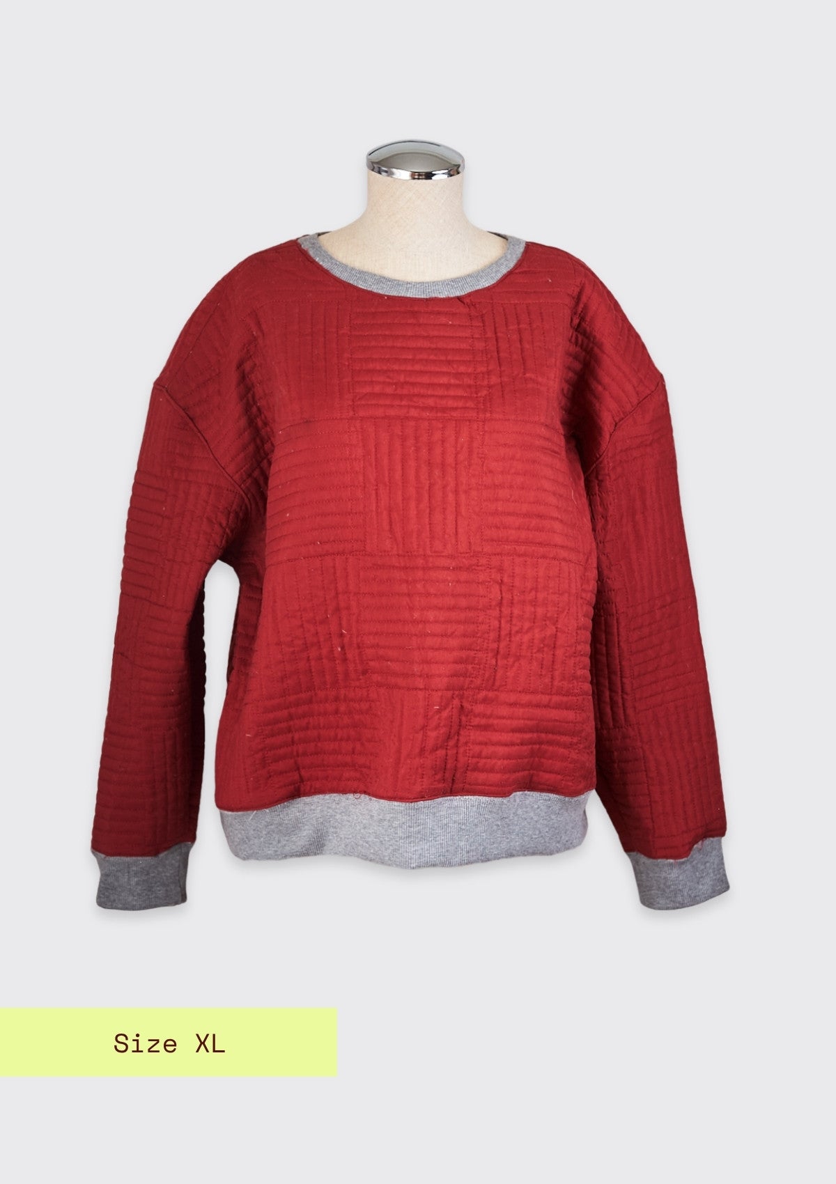Red textured crew neck sweater upcycled from a comforter on a mannequin with a gray collar against a white background