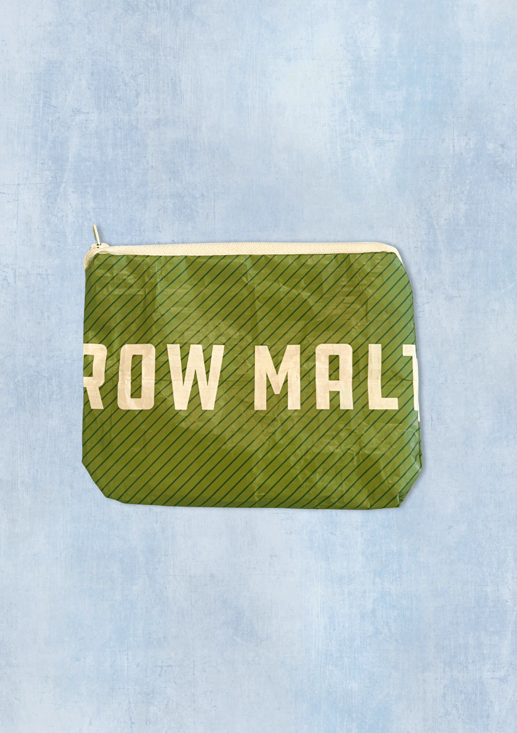 Green pouch upcycled from a malt bag with 'Row Malt' text on a light blue denim background