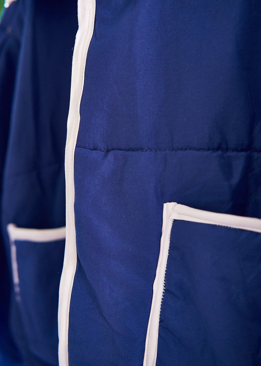 Close-up of a blue jacket with white trim on a blurred background