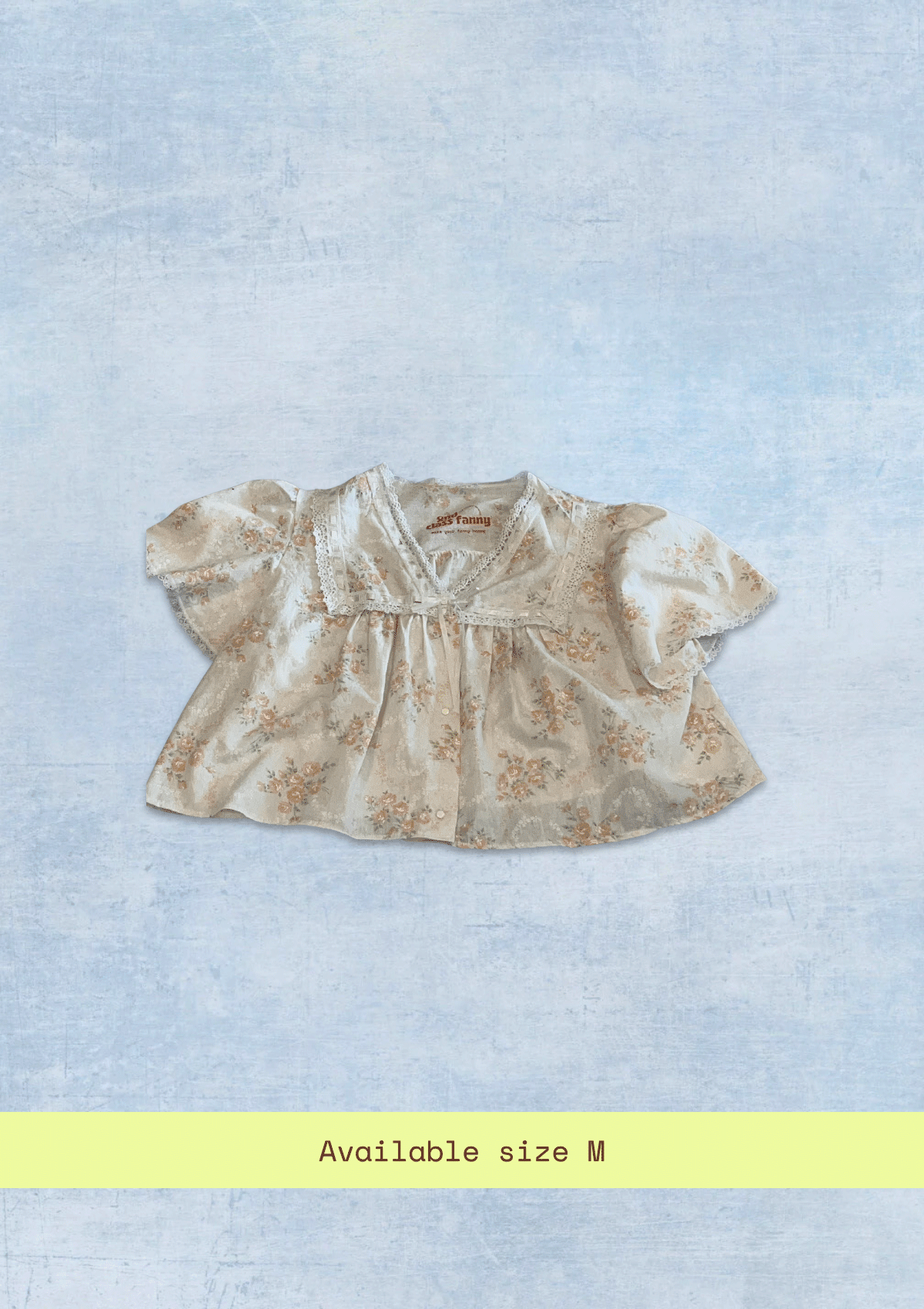 Floral blouse on a light blue textured background with size 'M' text.