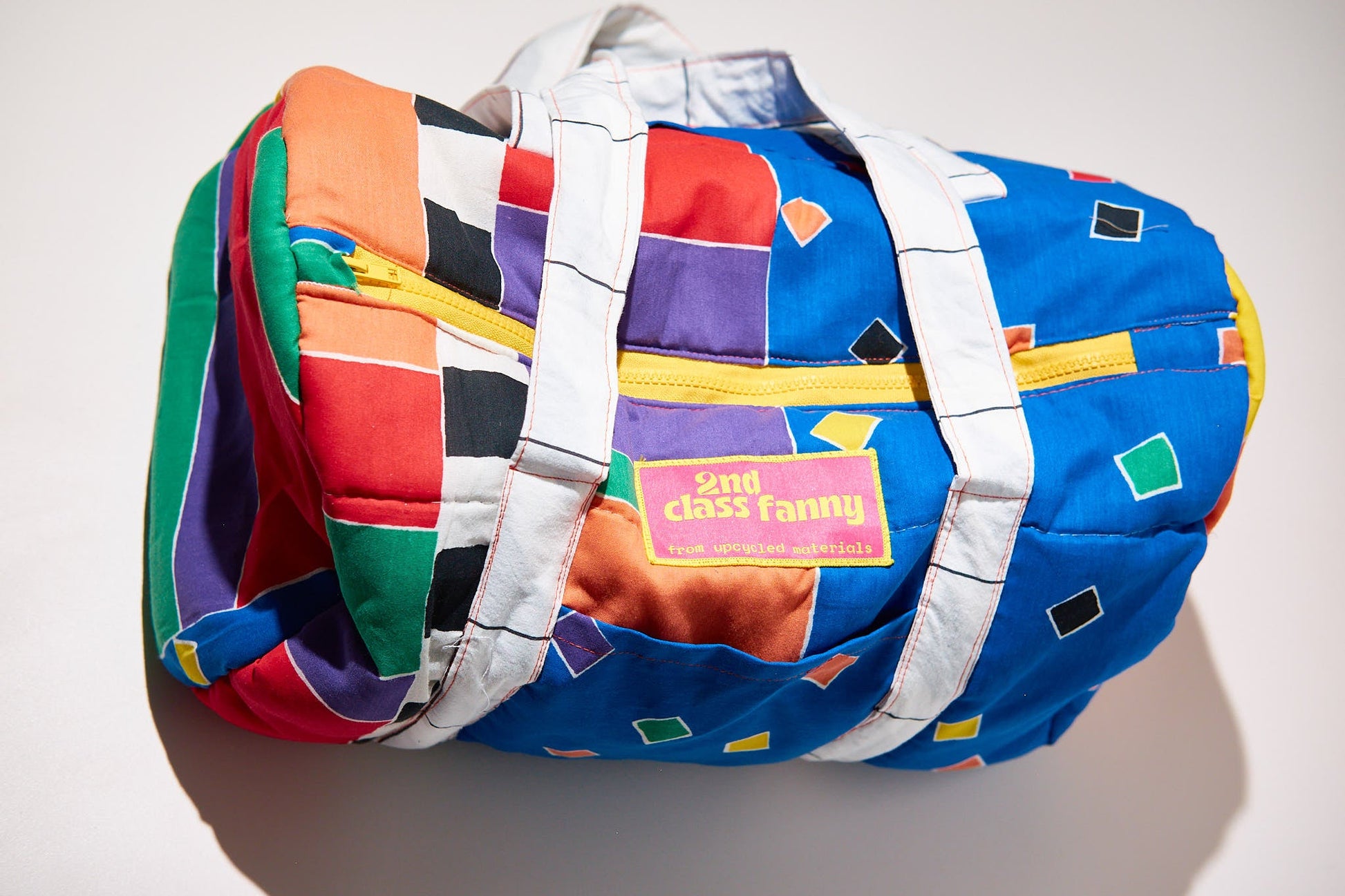 Colorful backpack with geometric pattern upcycled from comforter on a white background