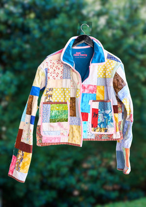 Colorful patchwork jacket hanging against a green leafy background