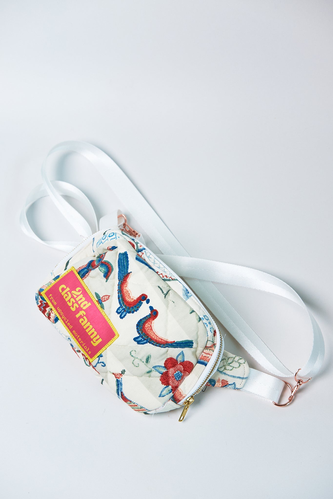 Floral-patterned Fanny pack upcycled from a quilt, with a strap on a light gray background