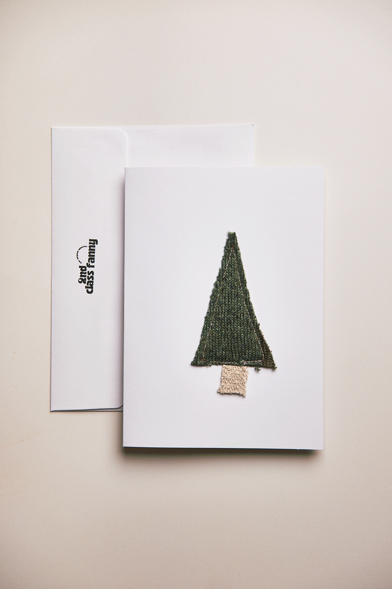 Greeting card with a green tree design on a beige background