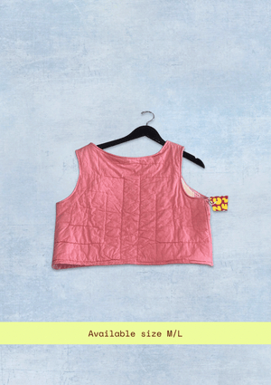 Pink crop top upcycled from a quilt on a hanger with a light blue background
