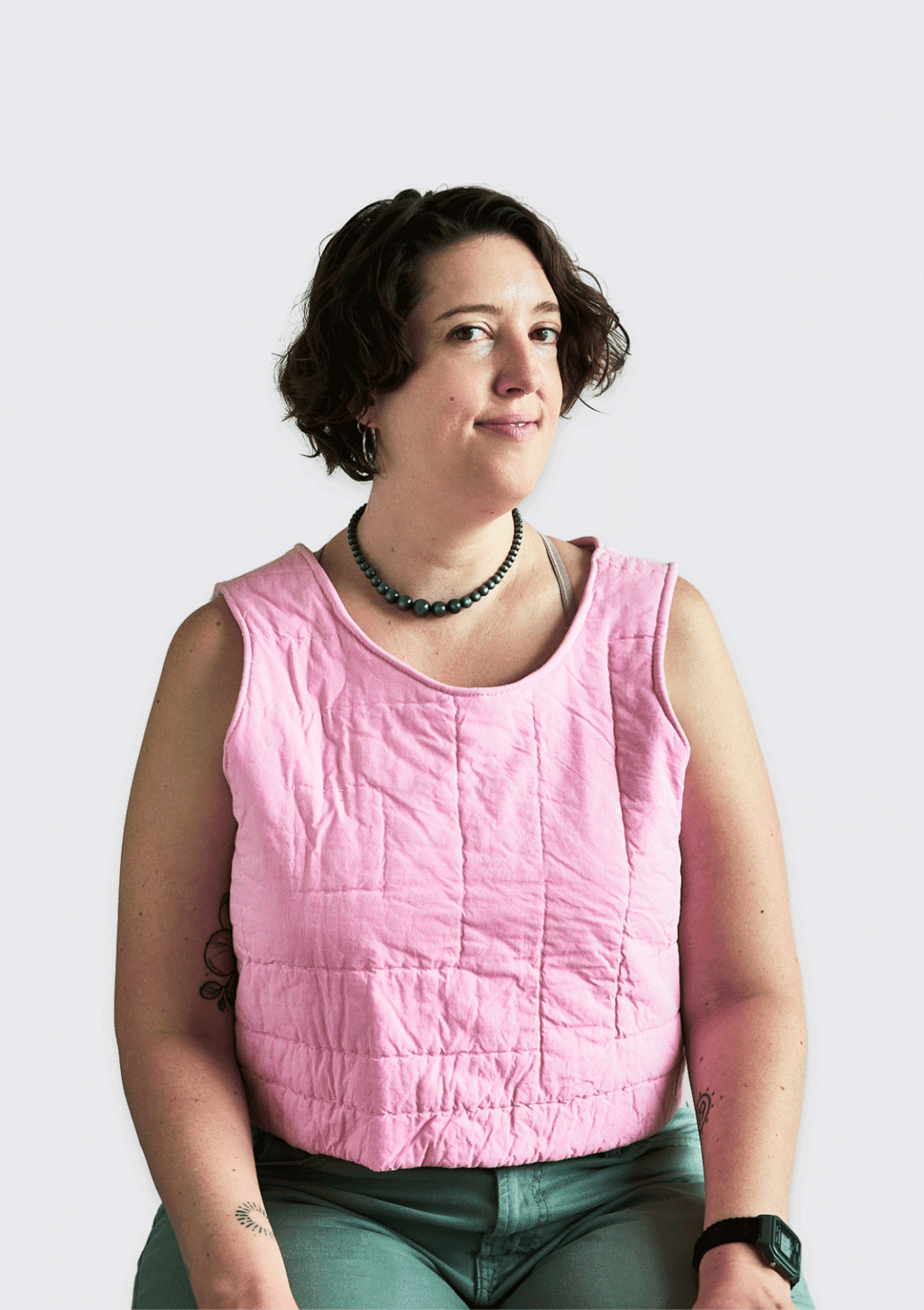 Person wearing a pink sleeveless top upcycled from a quilt against a white background