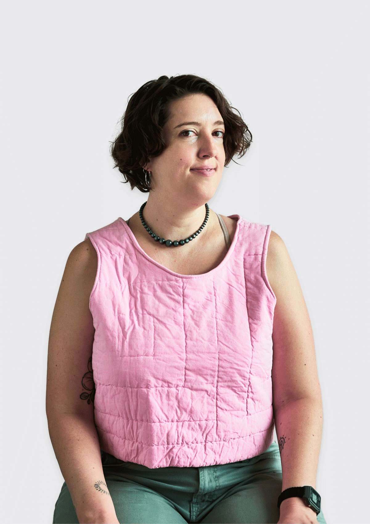 Person wearing a pink sleeveless top upcycled from a quilt against a white background