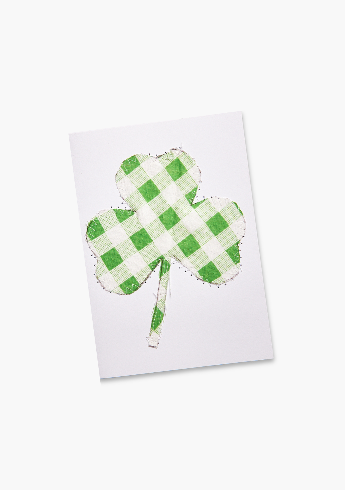 Green checkered shamrock on a white card made from upcycled bed sheets