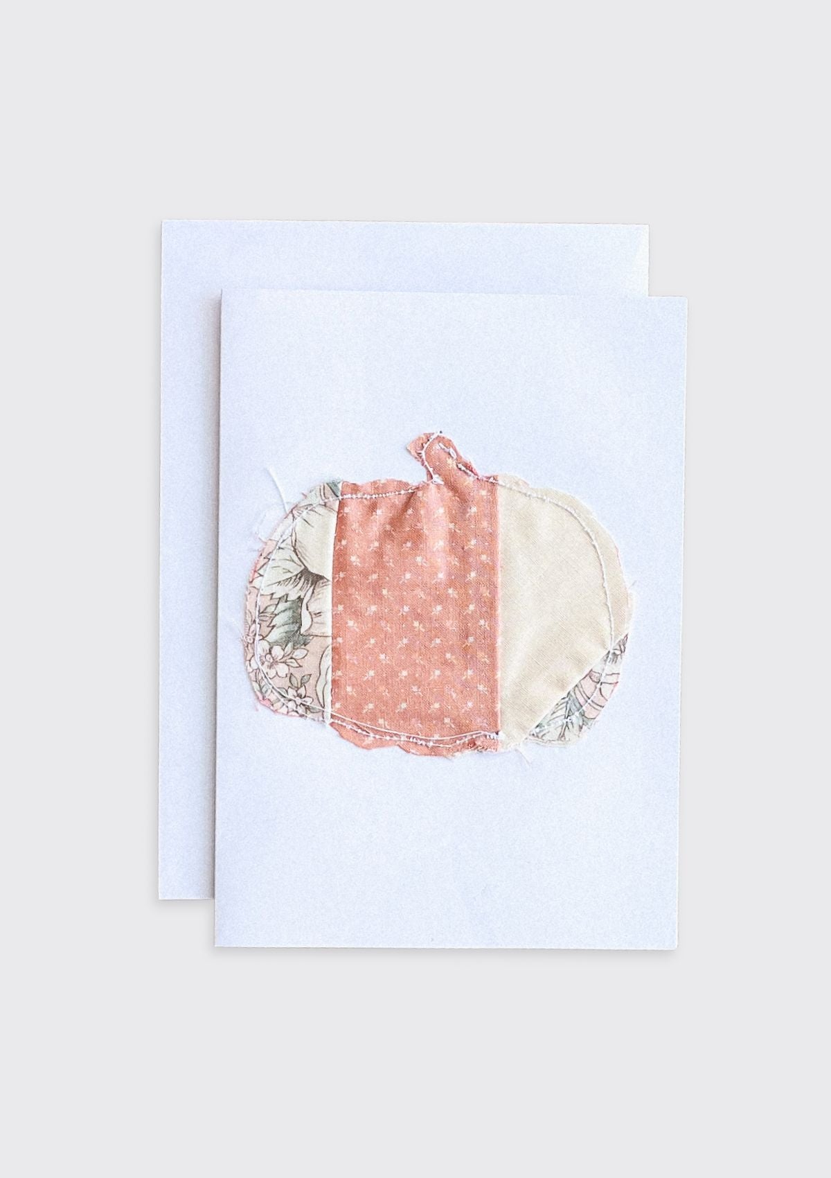 Greeting card with a colorful fabric pumpkin upcycled from quilt on a light cream background
