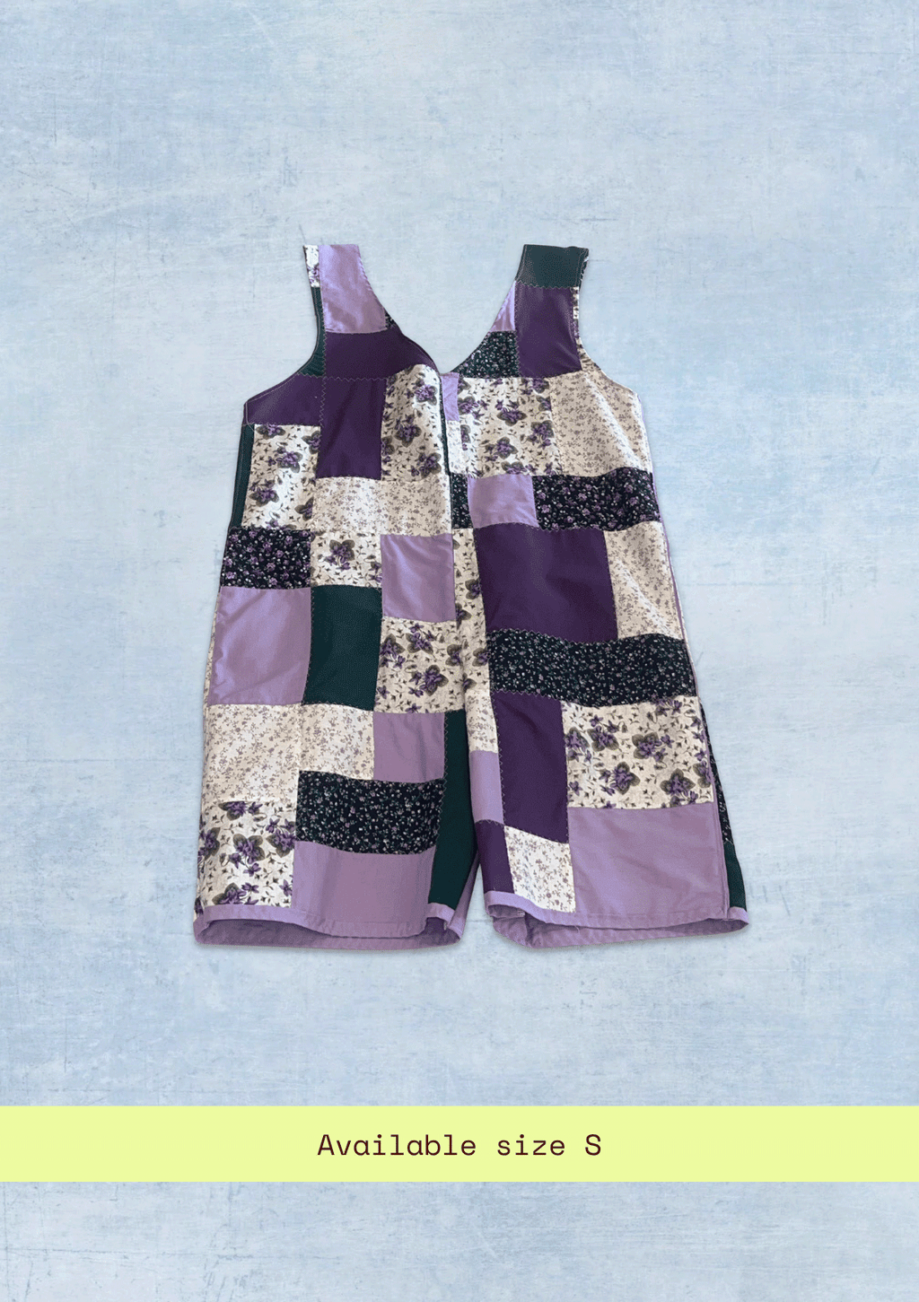 Patchwork romper / jumper with floral and geometric patterns on a light blue background