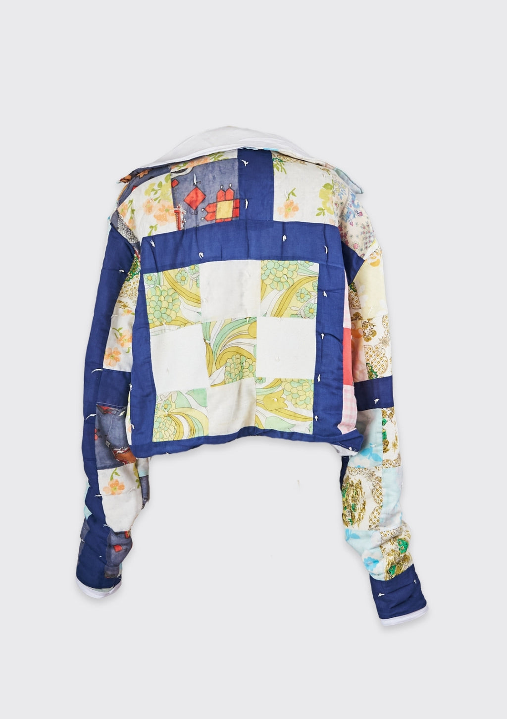 Colorful upcycled quilted jacket with a patchwork design on a white background
