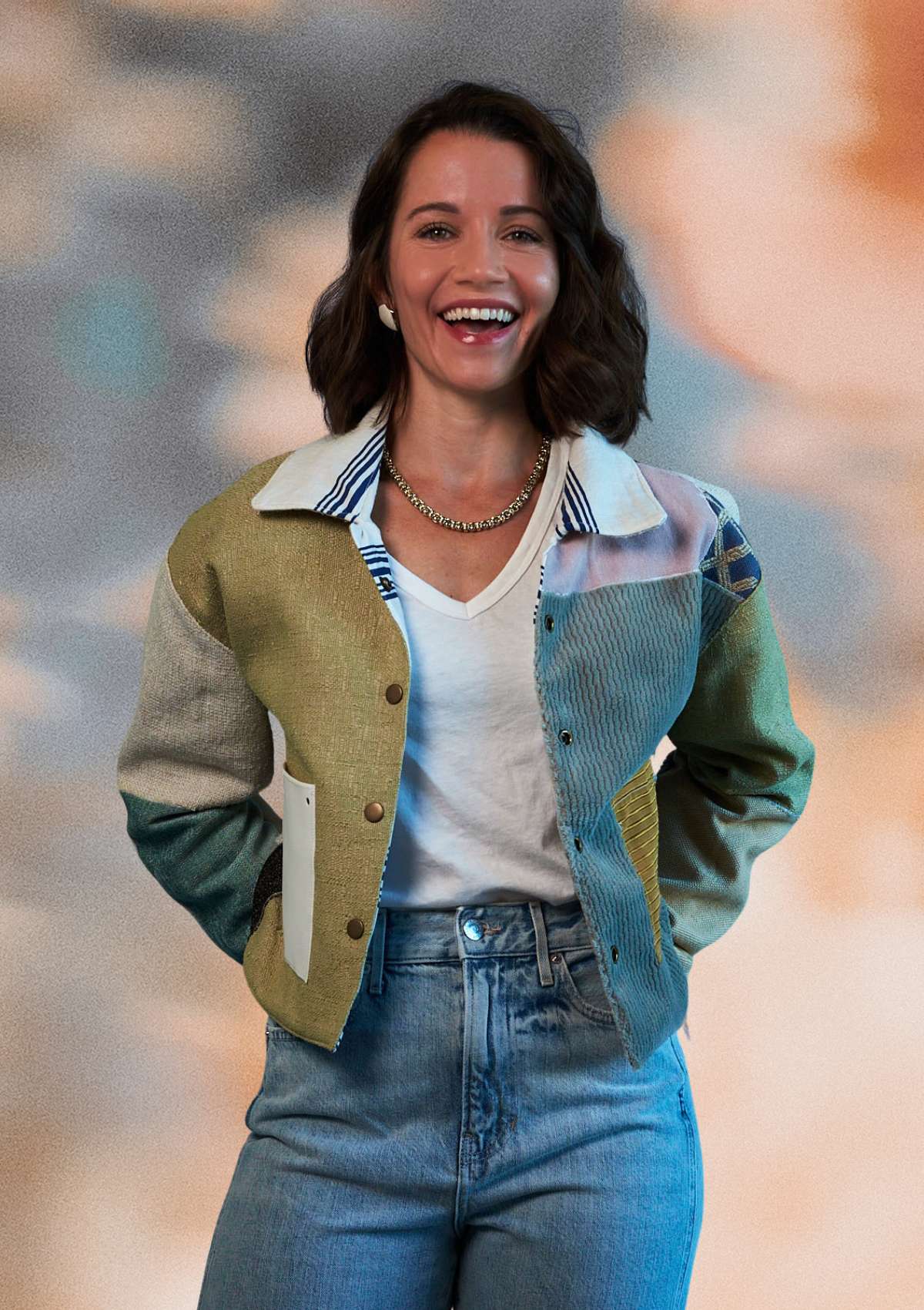 Woman wearing a patchwork jacket upcycled from upholstery swatches with a blurred background